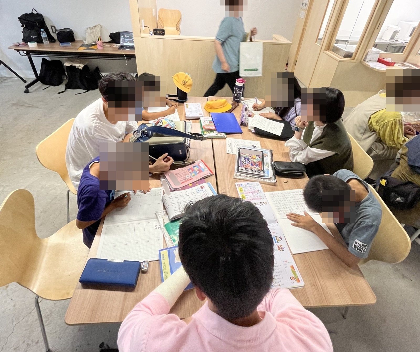 しゅくだいサポートで、宿題に取り組む子どもたちと大学生